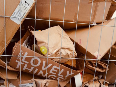 Photo of empty cardboard boxes in a large wire bin Photo by Azzedine Rouichi on Unsplash