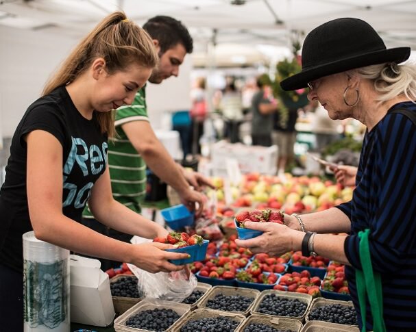 A photo of people looking at produce at an Edmonton farmers' market